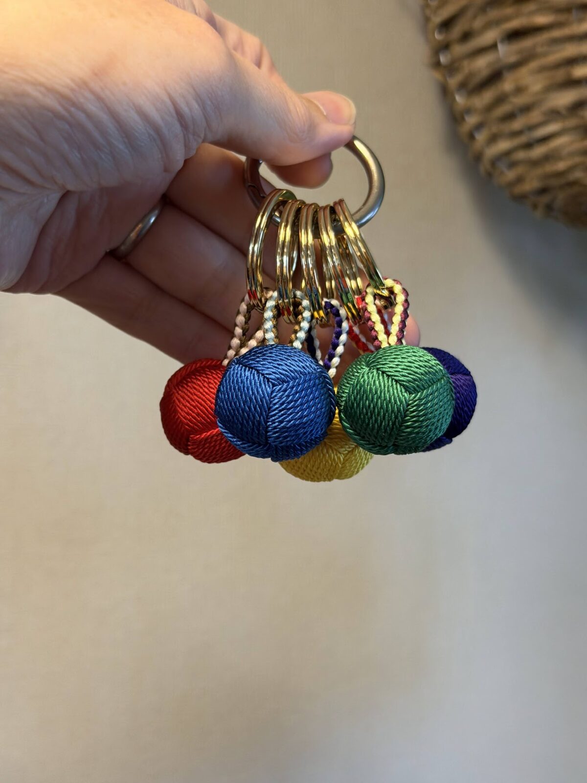 手のひらに５色のくみひもキーホルダーをまとめて持ったところ