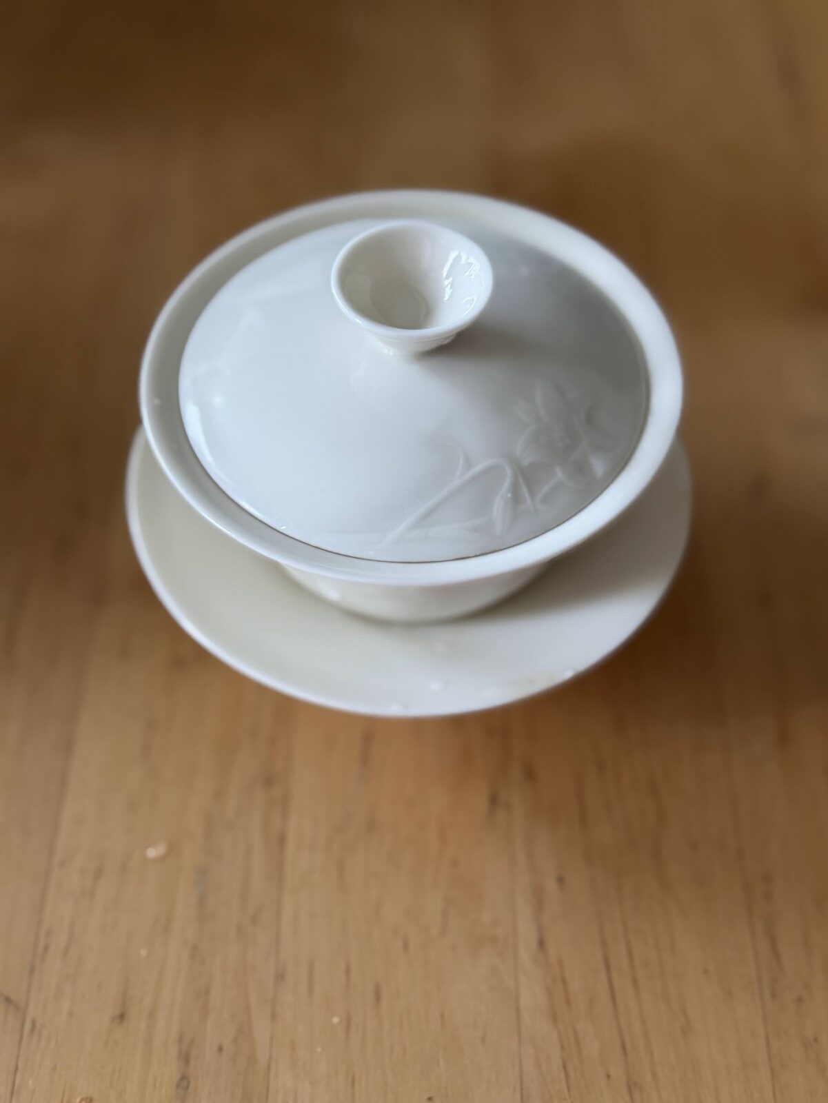 蓋を閉じた白い蓋椀。蓋には花のレリーフが浮き出ている