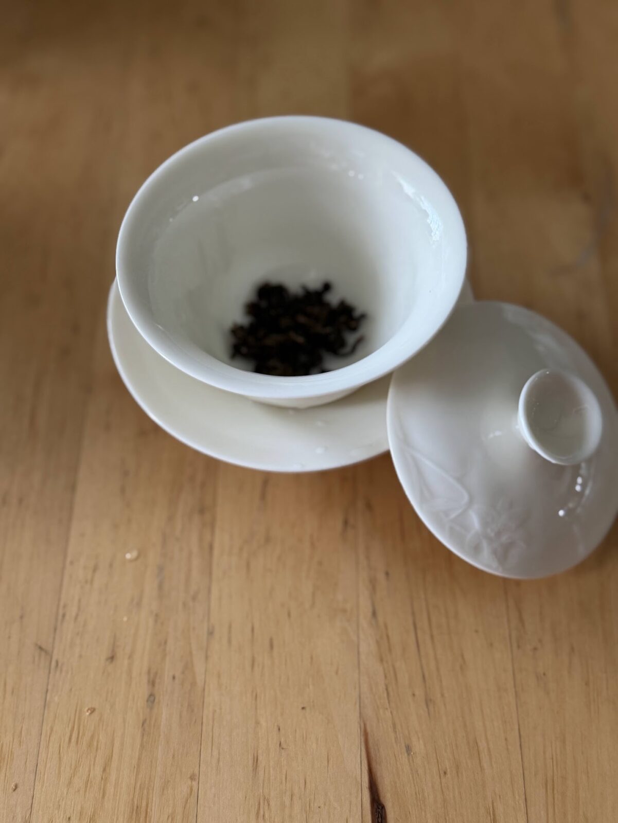白い蓋椀の蓋を開けて中国茶の茶葉を入れたところ