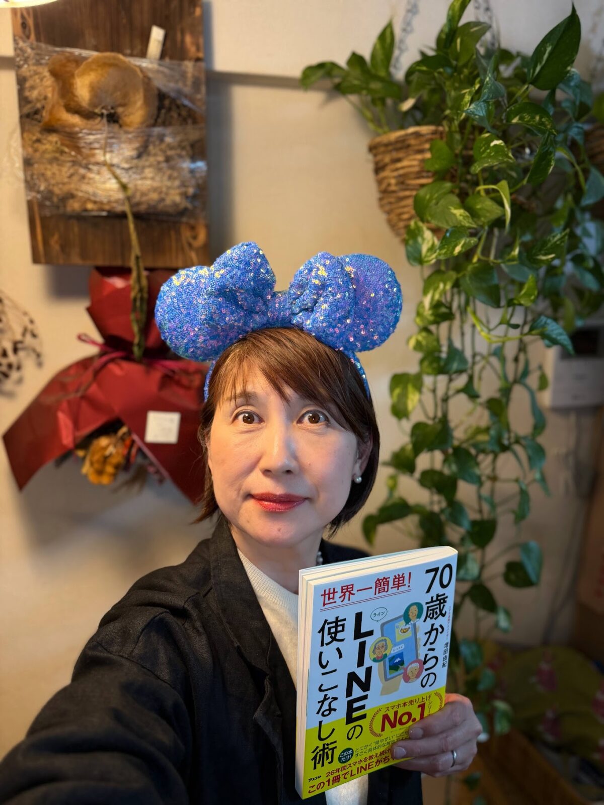 ミニーのカチューシャをつけて新刊を持つ
