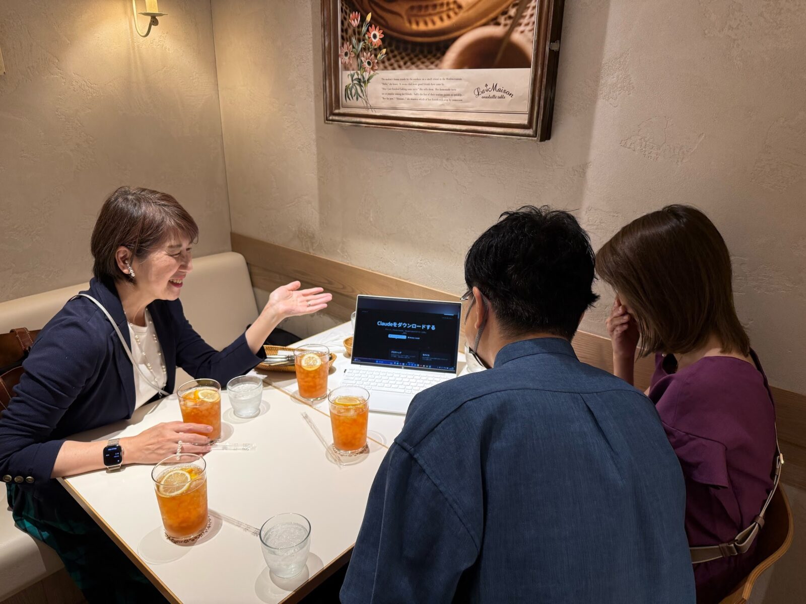ノートパソコンにClaudeのダウンロード画面を映して説明する会食の様子