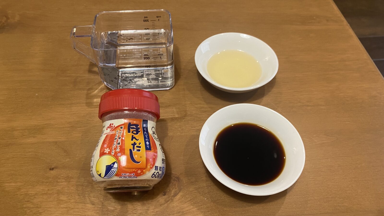 木のテーブルに水・みりん・しょうゆ・ほんだしを並べた、加工前の実際の写真