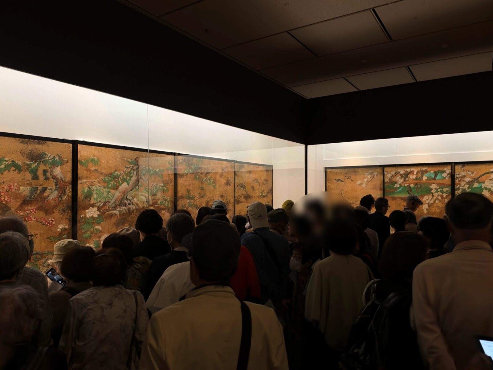 金地に花鳥が描かれた襖絵の前に集まるたくさんの来場者